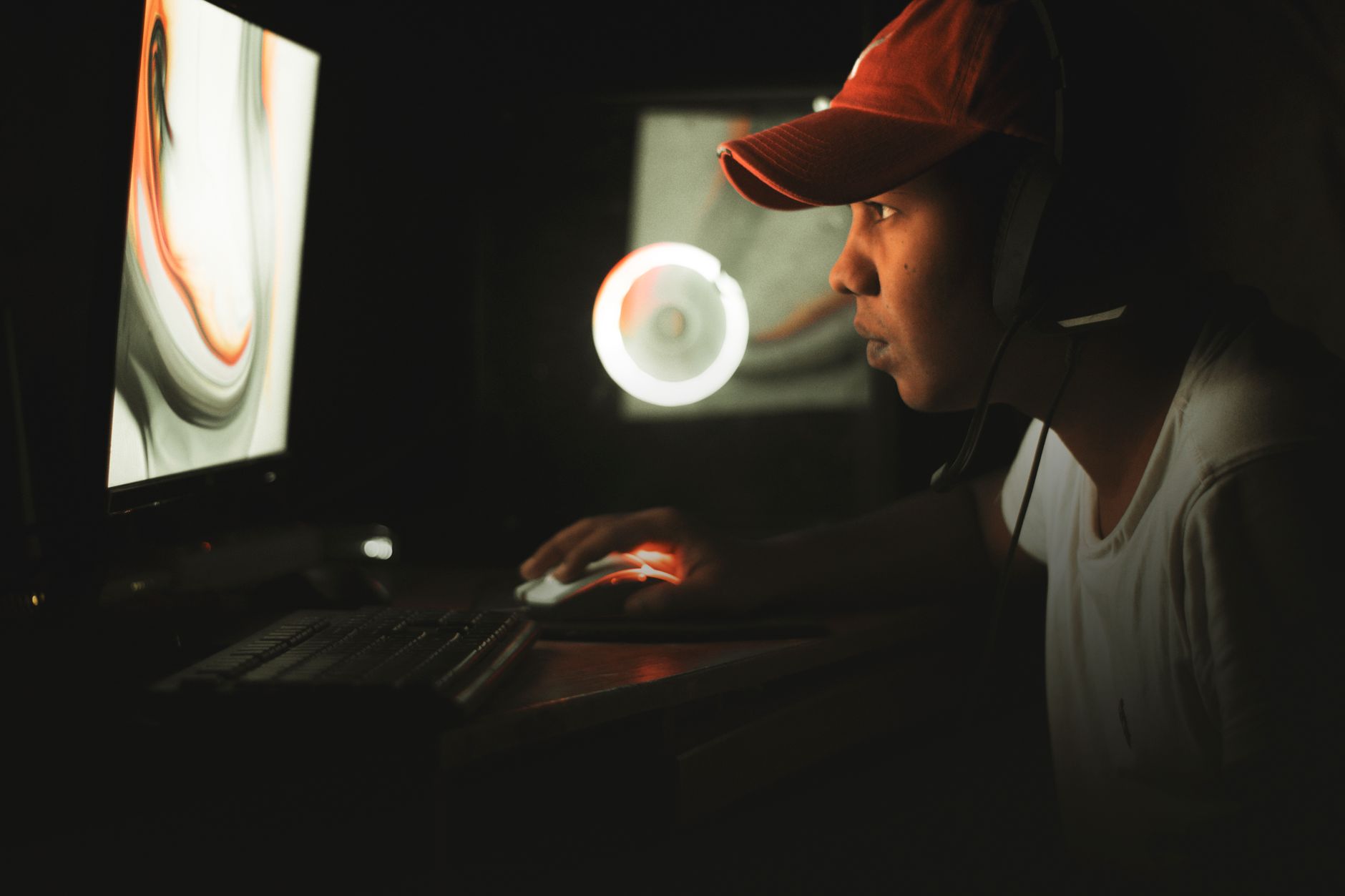 A gaming setup with a monitor glowing in a darkened room, representing late-night RPG sessions