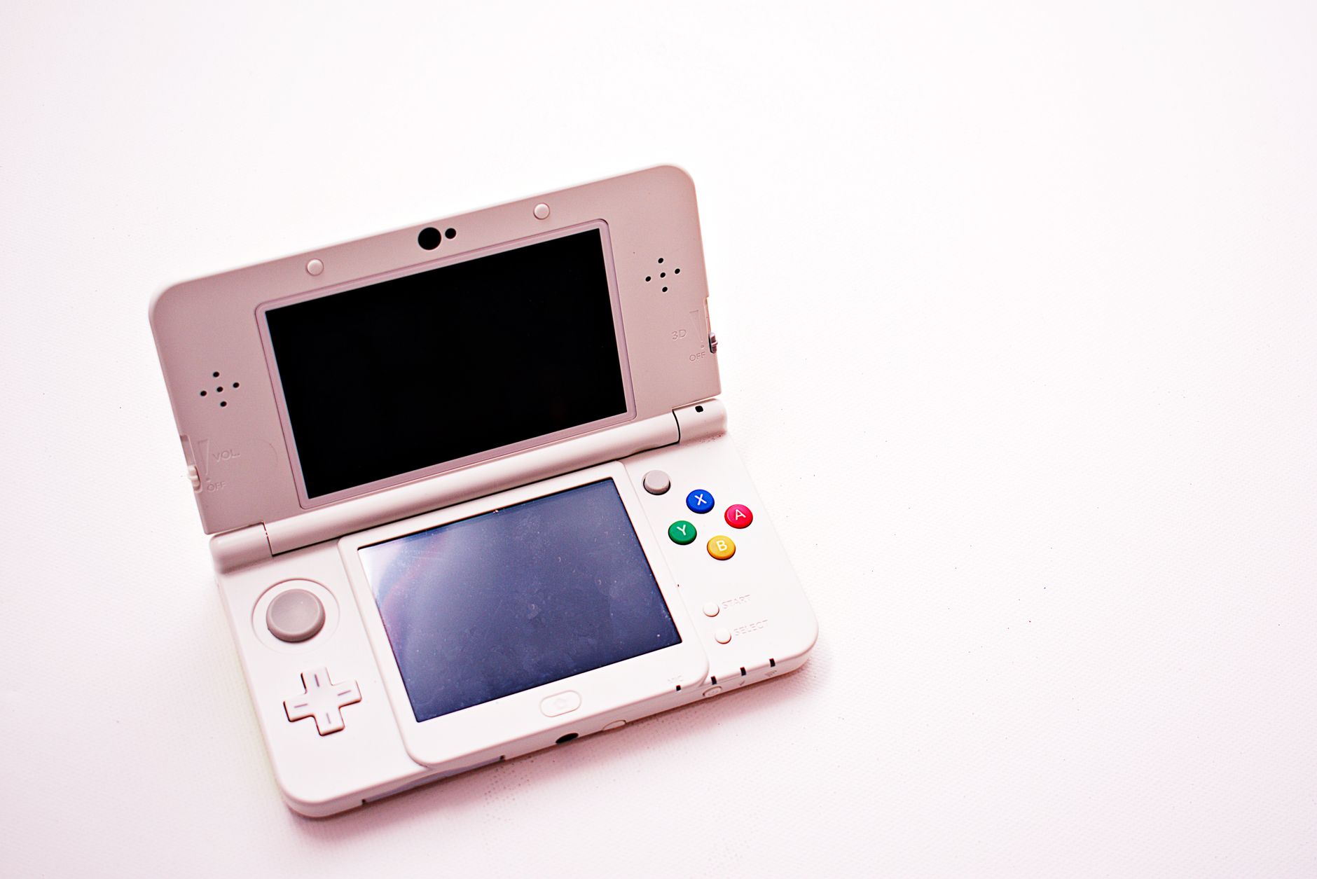 A person playing a handheld gaming device, representing the Nintendo DS platform that Okamiden was released on