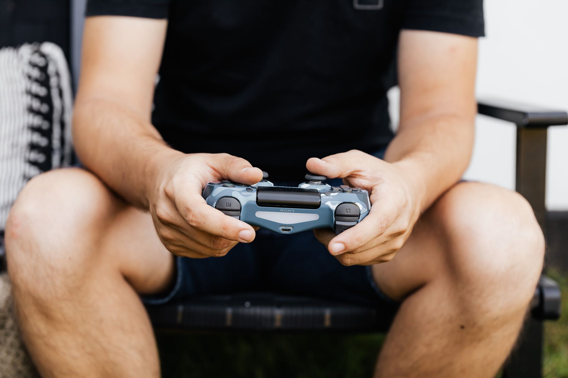 A person holding a gaming controller while playing a console game at home
