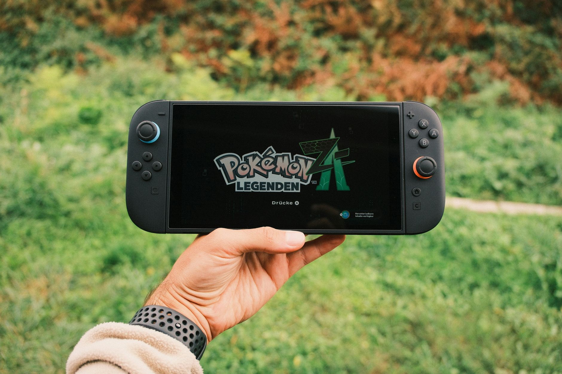 A Nintendo Switch handheld console being held by a player