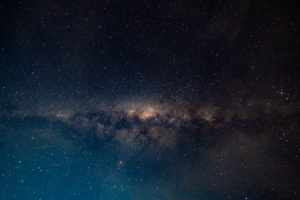 Dark starfield with glowing galaxy in deep space, representing science fiction exploration