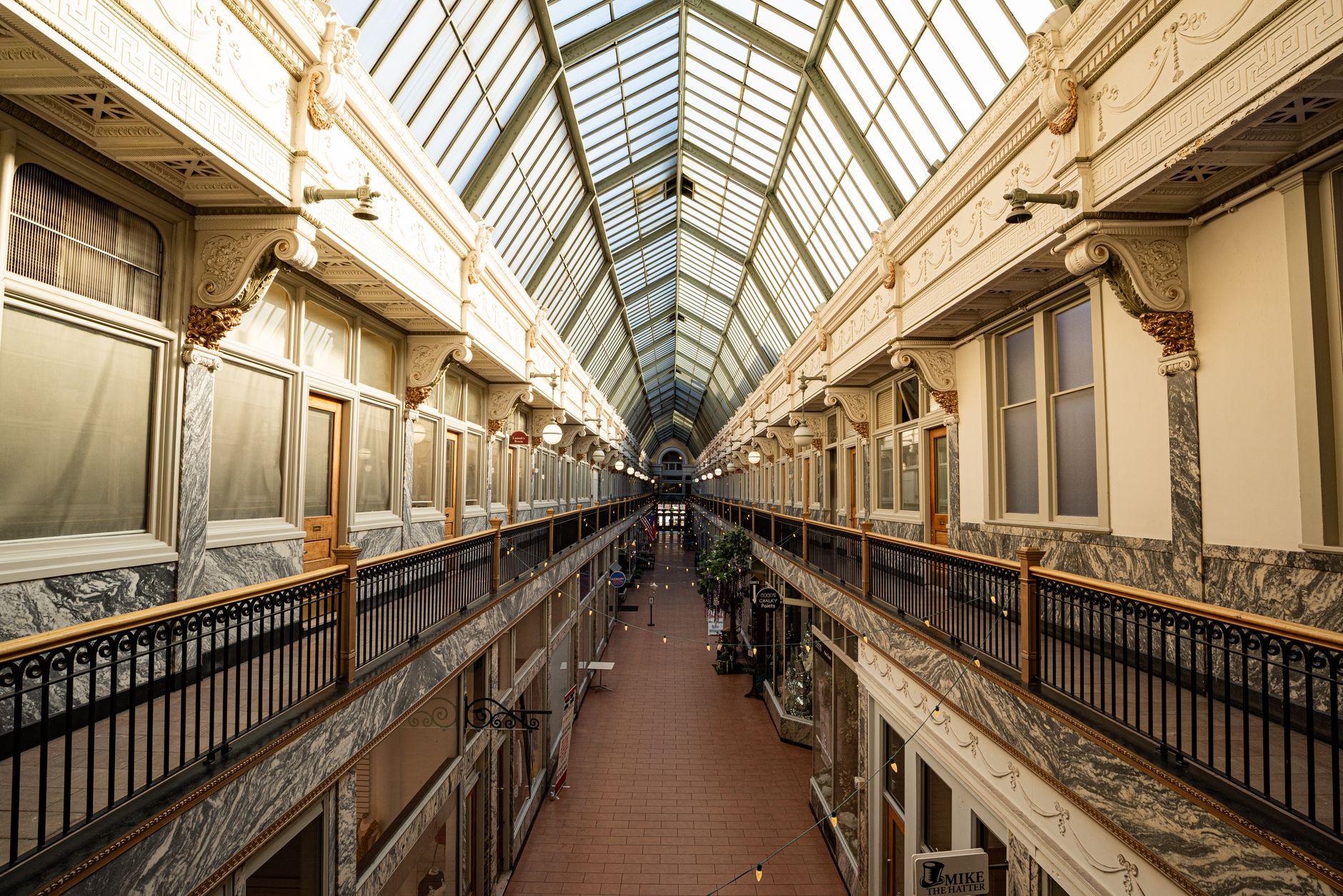 A dark, empty shopping mall corridor with dramatic lighting suggesting tension and abandonment