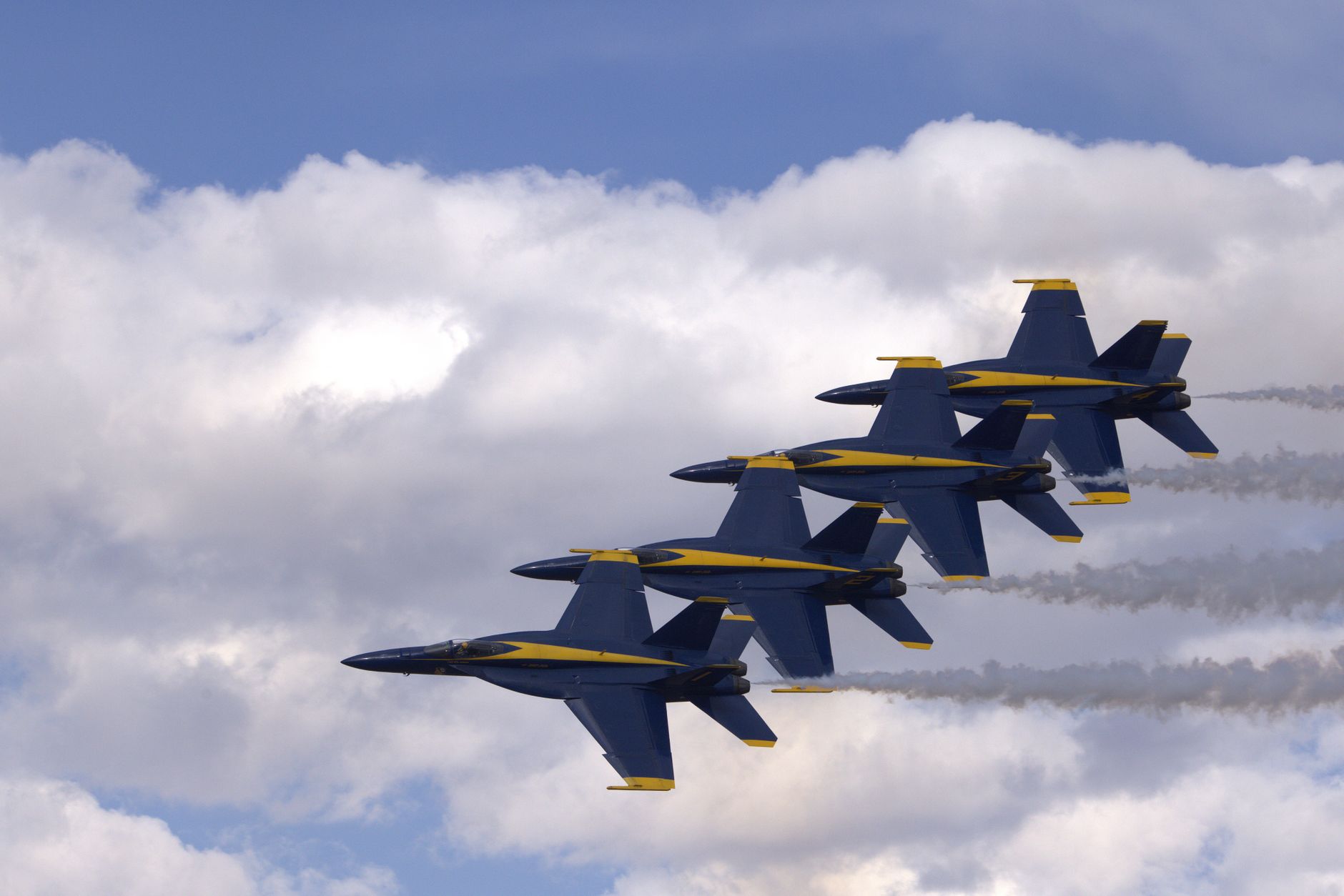 Fighter jet flying through a clear blue sky, representing the aerial action of the Ace Combat franchise