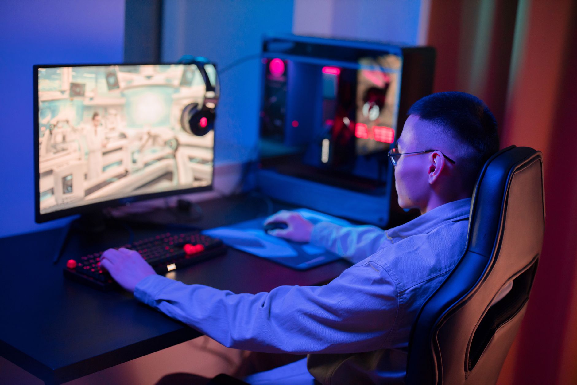 Gaming streamer at a desk with monitors and RGB lighting running a livestream